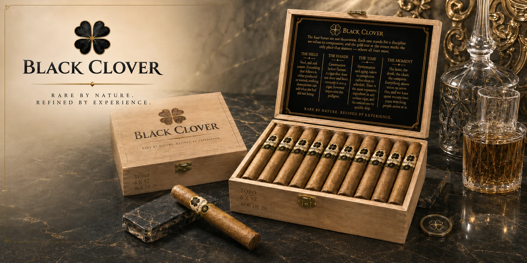 A Black Clover Toro cedar box of twenty, open beside a closed box and a single cigar